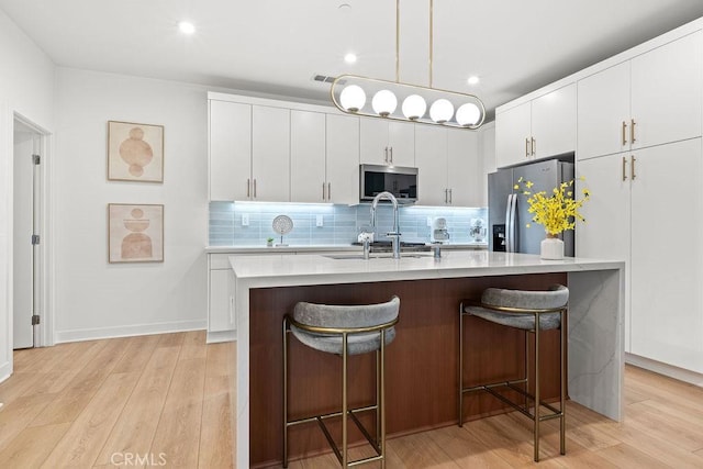 1707 W Bushell, Anaheim, CA 92805 - kitchen with a sink, light countertops, stainless steel appliances, light wood-style flooring, and a breakfast bar area