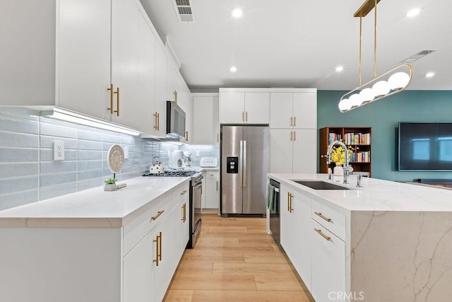 1707 W Bushell, Anaheim, CA 92805 - kitchen featuring tasteful backsplash, visible vents, a sink, light wood-type flooring, and appliances with stainless steel finishes