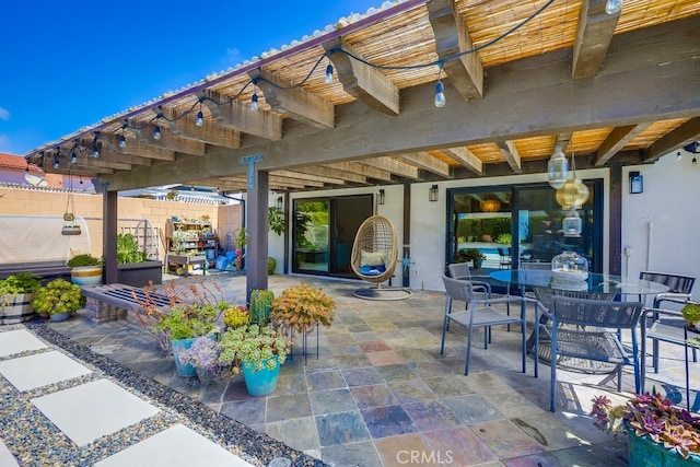 view of patio with outdoor dining area and fence