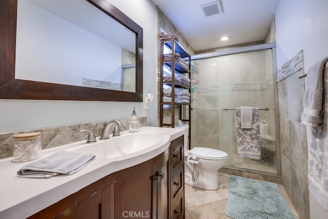 bathroom featuring a shower stall, toilet, vanity, and visible vents