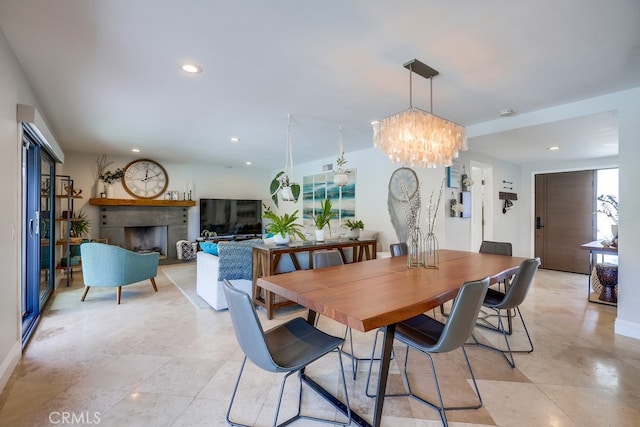 dining area with recessed lighting, a fireplace, and a notable chandelier