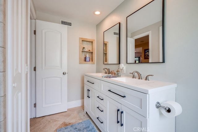 bathroom with a sink, visible vents, and double vanity