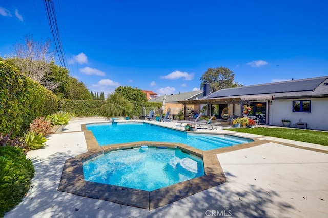 outdoor pool with fence, a patio, a diving board, and an in ground hot tub