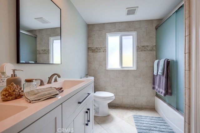 full bathroom with tile walls, tile patterned floors, vanity, and plenty of natural light