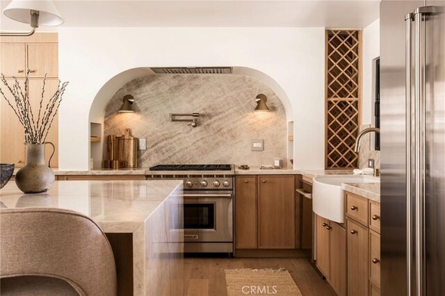 521 Fremont Dr, Pasadena, CA 91103 - kitchen featuring high end appliances, light wood-type flooring, and brown cabinetry