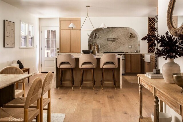 521 Fremont Dr, Pasadena, CA 91103 - kitchen with stove, a kitchen breakfast bar, light wood finished floors, and light countertops