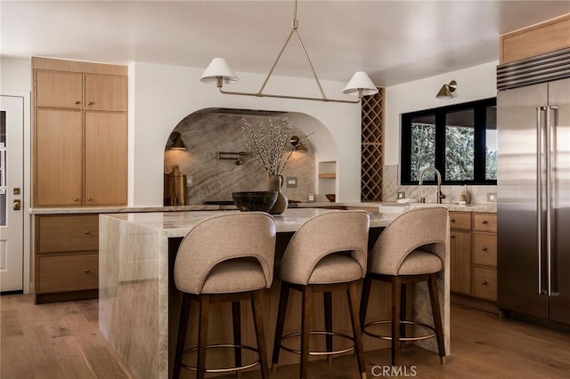 521 Fremont Dr, Pasadena, CA 91103 - kitchen featuring stainless steel built in fridge, backsplash, light wood-type flooring, and a kitchen bar