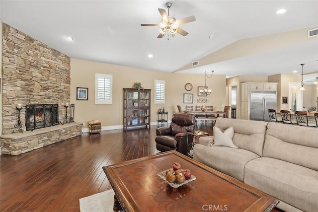 living area with dark wood-style floors, vaulted ceiling, visible vents, and ceiling fan