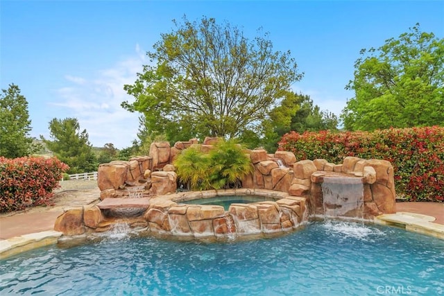 view of swimming pool with an in ground hot tub