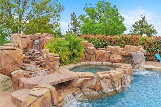 view of pool with an in ground hot tub