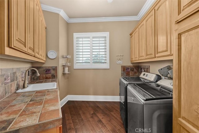 laundry room featuring baseboards, separate washer and dryer, a sink, ornamental molding, and cabinet space