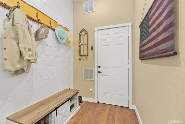 mudroom with visible vents, baseboards, and wood finished floors