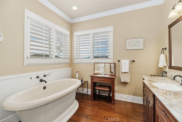 bathroom with vanity, baseboards, a soaking tub, crown molding, and hardwood / wood-style floors