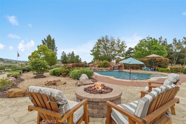 outdoor pool featuring a patio and a fire pit