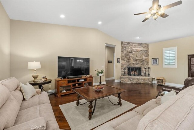 living room featuring baseboards, a stone fireplace, wood finished floors, and ceiling fan