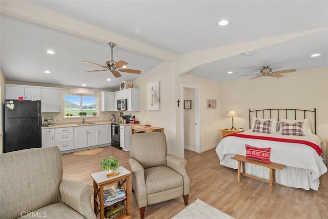 bedroom with vaulted ceiling with beams, light wood-type flooring, freestanding refrigerator, and baseboards