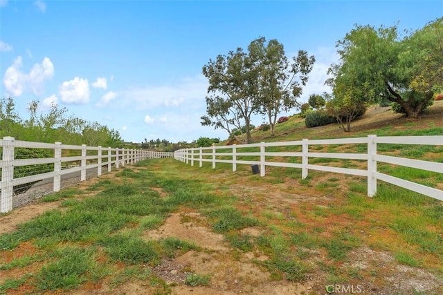 view of yard with a rural view and fence