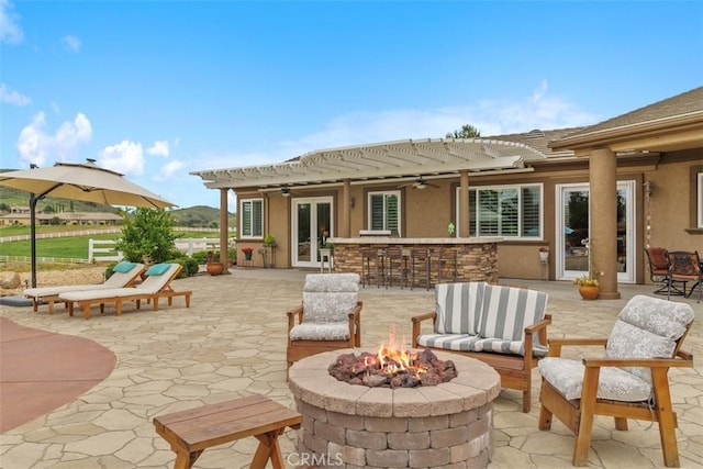 rear view of property with an outdoor fire pit, french doors, a patio area, and stucco siding