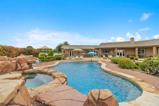 pool featuring a patio and an in ground hot tub