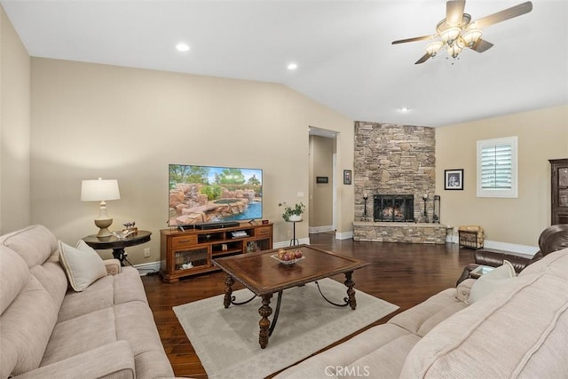 living area with vaulted ceiling, wood finished floors, a ceiling fan, baseboards, and a fireplace