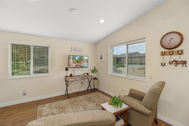 living area featuring recessed lighting, vaulted ceiling, wood finished floors, and baseboards