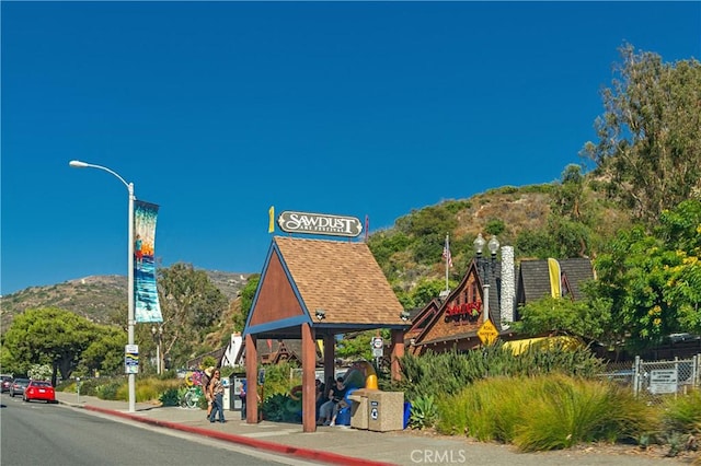 exterior space with curbs, street lighting, a mountain view, and sidewalks