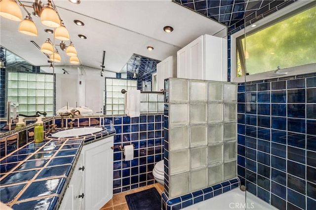 full bathroom with recessed lighting, toilet, vanity, tile walls, and a shower