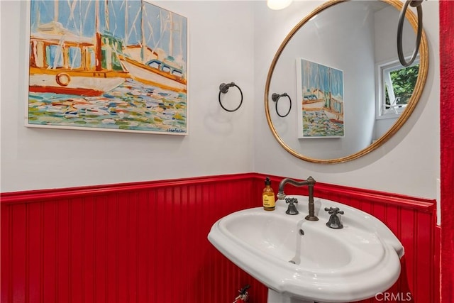 bathroom with a wainscoted wall and a sink