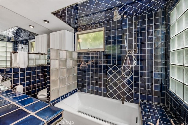 full bathroom with recessed lighting, tile walls, toilet, and bathing tub / shower combination