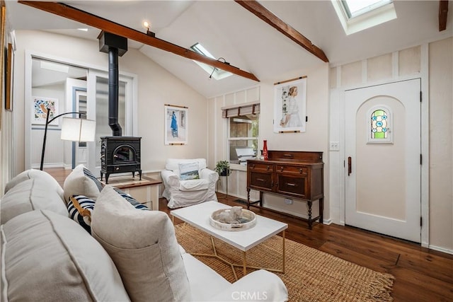living room with wood finished floors, lofted ceiling with skylight, and a wood stove