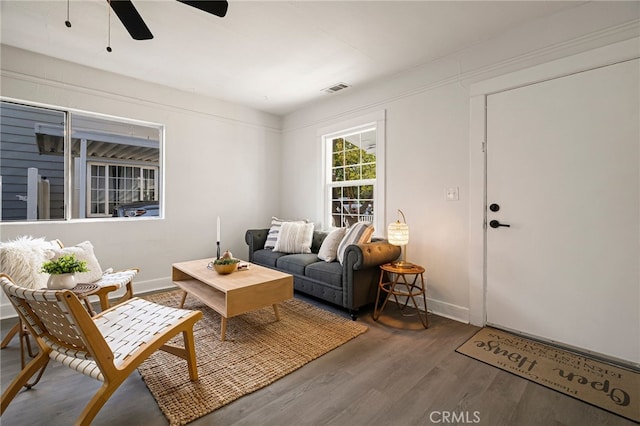living room featuring visible vents, ceiling fan, wood finished floors, and baseboards