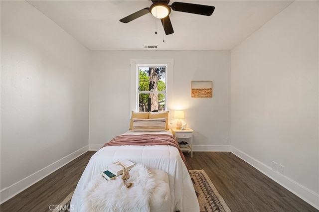 bedroom featuring visible vents, baseboards, a ceiling fan, and wood finished floors