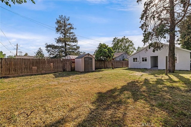 view of yard featuring a fenced backyard, a shed, and an outdoor structure