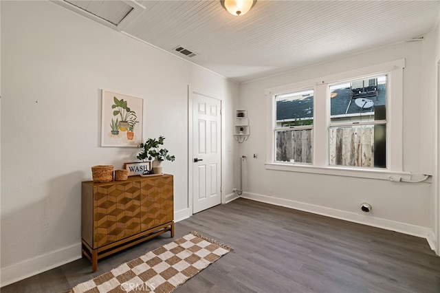 foyer featuring visible vents, baseboards, and wood finished floors