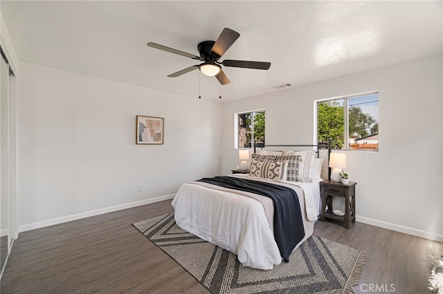 bedroom with visible vents, baseboards, ceiling fan, and wood finished floors