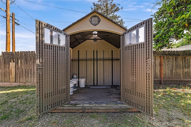 view of outdoor structure with fence and an outbuilding