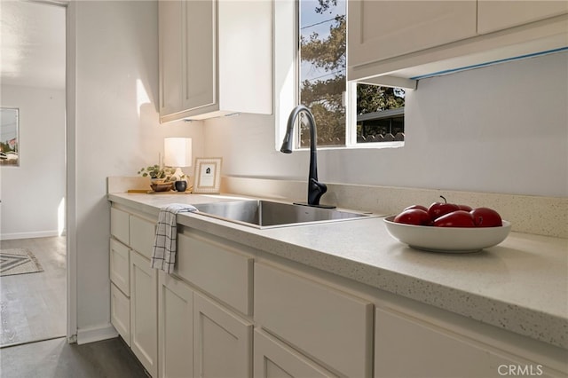 411 A St, Orland, CA 95963 - kitchen featuring a sink, light countertops, baseboards, white cabinets, and dark wood-type flooring