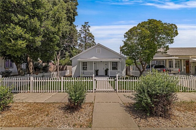 411 A St, Orland, CA 95963 - bungalow-style home featuring a porch, a fenced front yard, and stucco siding