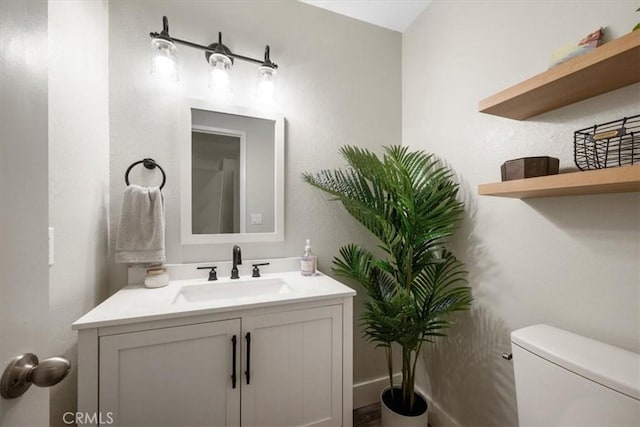 half bath featuring toilet and vanity