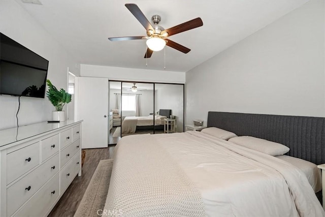 bedroom featuring a ceiling fan, a closet, and dark wood-style floors