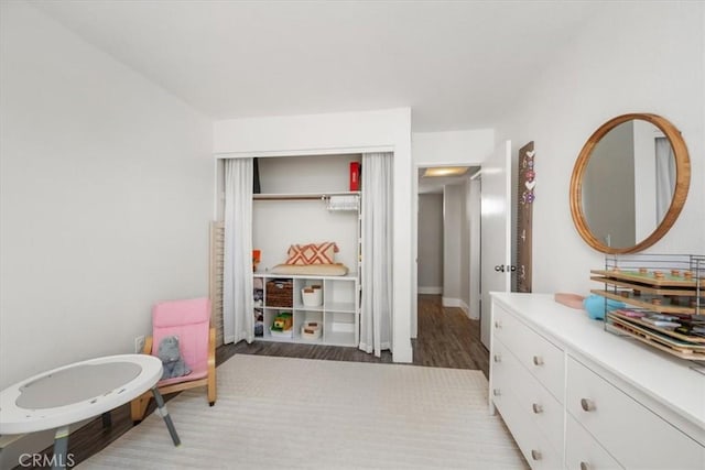 bedroom featuring a closet, light wood finished floors, and baseboards