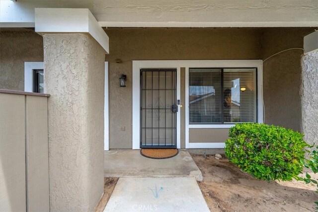 doorway to property featuring stucco siding