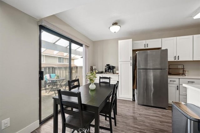 dining space with baseboards and wood finished floors