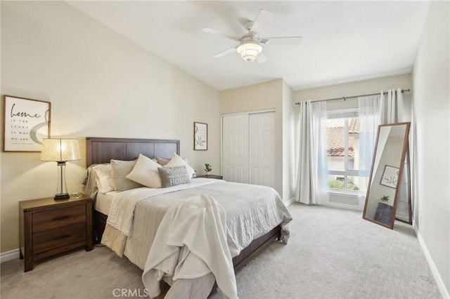 bedroom featuring a closet, baseboards, a ceiling fan, and light carpet