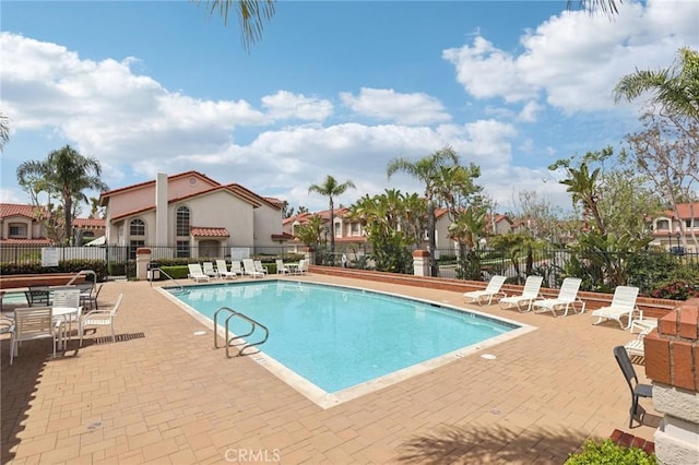 community pool featuring a patio and fence