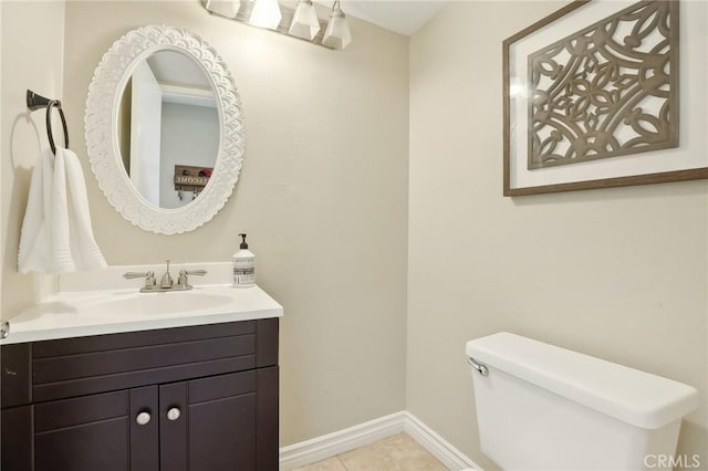 bathroom featuring tile patterned flooring, toilet, vanity, and baseboards