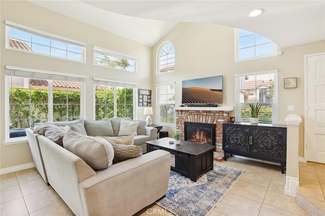 living room featuring baseboards, light tile patterned flooring, a towering ceiling, and a fireplace