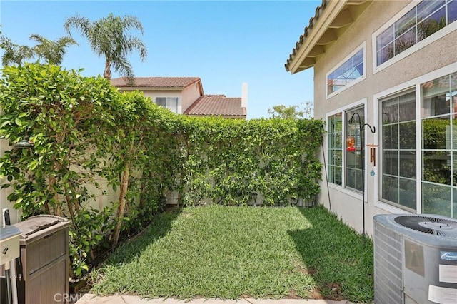 view of yard featuring central AC unit and a fenced backyard