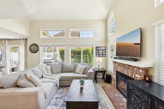 living area featuring a high ceiling and a brick fireplace