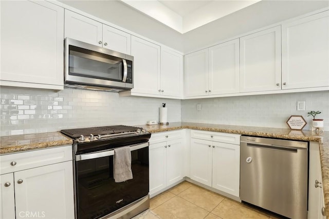 kitchen with white cabinetry, light tile patterned flooring, light stone countertops, decorative backsplash, and stainless steel appliances